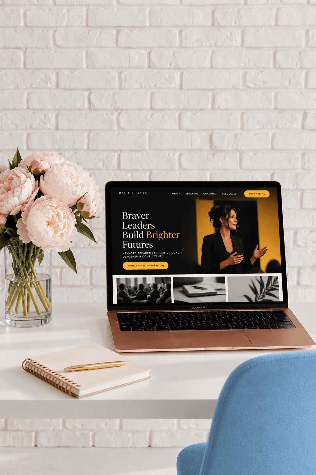 Laptop showing an executive coach’s website on a white desk with peonies